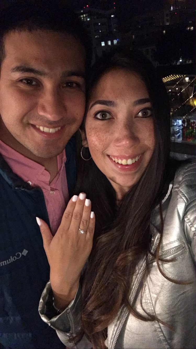 Camila y Fernando sonriendo y mostrando el anillo de compromiso